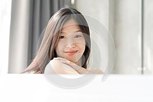 Young Asian woman relaxing in a bath . Female skincare concept.