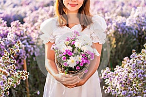 Young woman relaxing and enjoying in blooming flowers field in the morning