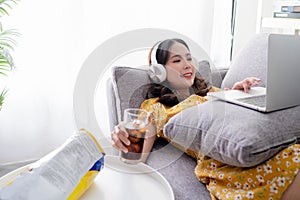Young Asian woman are relaxing using social media follow news on tablet. She works at home