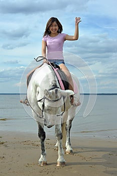 Young asian woman riding white horse