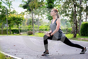 Young asian woman runner doing stretch exercise stretching legs