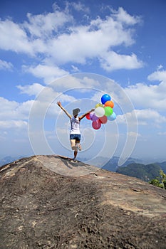 Young asian woman running with colored balloons