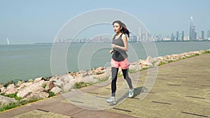 Young asian woman running jogging in seaside park
