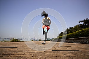 Young asian woman running outdoors