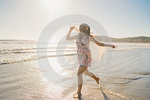 Young Asian woman running and playing on beach, Beautiful female relax on beach near sea when sunset in evening. Lifestyle woman