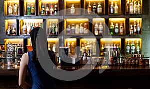 Young Asian woman with a sad face drinking cocktails in front of a vintage bar, Relaxing activities after work or hangouts