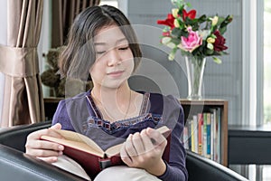 Young asian woman short hair read a book in living room