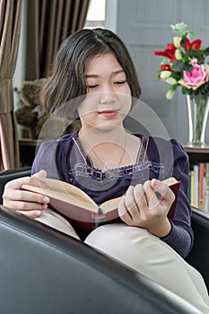 Young asian woman short hair read a book in living room