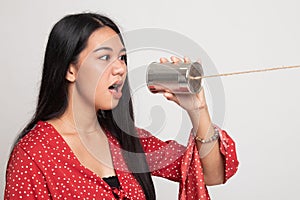 Young Asian woman shout with tin can phone