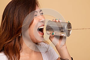 Young Asian woman shout with tin can phone