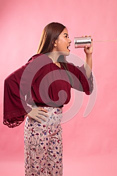 Young Asian woman shout with tin can phone