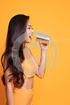 Young Asian woman shout with tin can phone