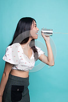 Young Asian woman shout with tin can phone