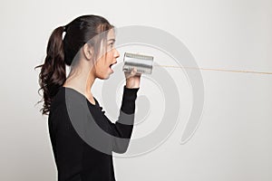 Young Asian woman shout with tin can phone