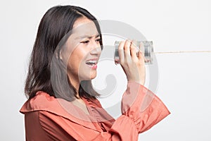 Young Asian woman shout with tin can phone