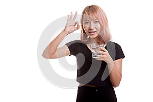 Young Asian woman show OK with a glass of drinking water.