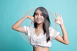 Young Asian woman show with phone gesture and OK sign