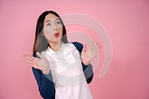 Young Asian woman showing an emotional surprise, standing with gasped on a pink background. She was shocked