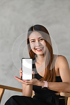 Young asian woman showing smart phone with empty screen.