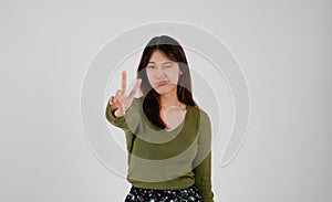 Young asian woman showing two fingers, positive or peace gesture, on white background