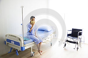 Young Asian woman is sick, headache has a high fever, sneezing, is recuperating in the hospital room. photo