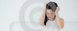 Young asian woman sitting on bed pain headache in the bedroom at home.