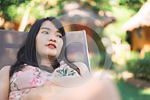 Young Asian woman sitting on bench relax on beach, Beautiful female happy relax near sea. Lifestyle women travel on beach concept