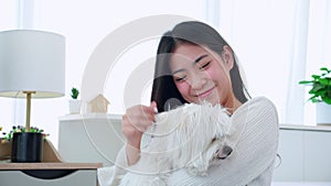 Young asian woman sitting carrying with fluffy dog shih tzu with love in bedroom at home, friends pet with companion.