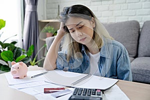 Young Asian woman sitting expression face stressed by calculate expense on table from invoice or bill