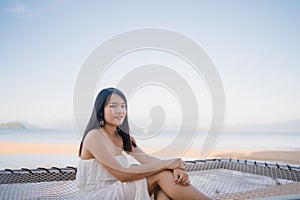 Young Asian woman sitting on hammock relax on beach