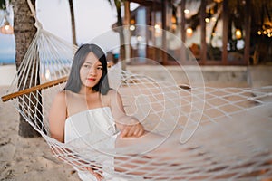 Young Asian woman sitting on hammock relax on beach, Beautiful female happy relax near sea. Lifestyle women travel on beach