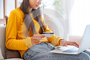Young asian woman sitting on sofa in living room