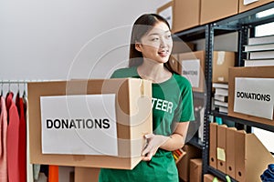 Young asian woman smiling with donated box at donations stand