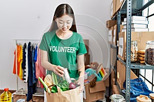 Young asian woman smiling with donated food at donations stand