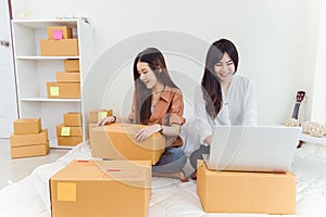 Young Asian woman startup small business entrepreneur SME distribution warehouse with parcel mail box. Owner home office concept.