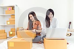 Young Asian woman startup small business entrepreneur SME distribution warehouse with parcel mail box. Owner home office concept.