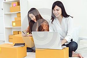 Young Asian woman startup small business entrepreneur SME distribution warehouse with parcel mail box. Owner home office concept.