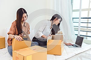 Young Asian woman startup small business entrepreneur SME distribution warehouse with parcel mail box. Owner home office concept.