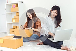 Young Asian woman startup small business entrepreneur SME distribution warehouse with parcel mail box. Owner home office concept.