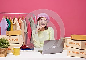 Young asian woman startup small business freelance sale fashion clothing with parcel box and computer laptop on table and sitting