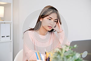 Young asian woman stress while working with laptop computer at home office