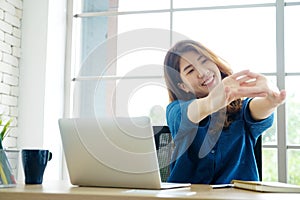 Young asian woman stretching body for relaxing while working wit