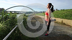 Young asian woman stretching before a run near the river in Taipe city