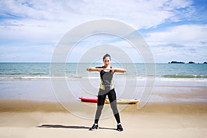 Young Asian woman is stretching or warm-up her body before exercise by running on the beach in the morning and get fresh air.