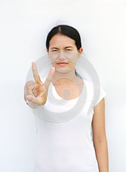 Young asian woman in T-Shirt Showing expression a two-finger victory, Selected focus at her finger