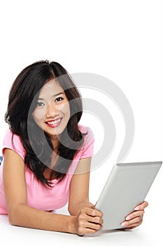 Young asian woman with a tablet pc , laying on the floor isolat