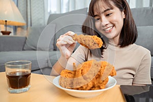 Young asian woman takeaway eating junk food chicken nuggets wing, Female having fun enjoying fast food