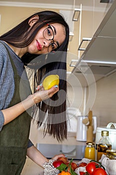 Young Asian woman takes out lemon from a grocery bag. Reusable package. Zero waste