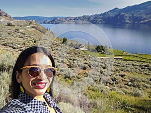 Young Asian woman taking selfie at Okanagan lake Canada