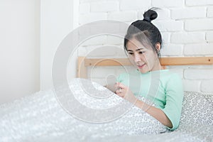 Young Asian woman taking selfie photo in bedroom